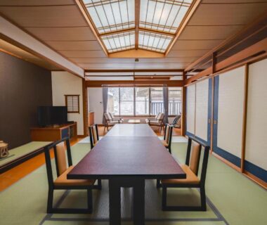 Traditional tatami dining room with low table, backrest chairs and shoji screens at Seifutei in Fukushima