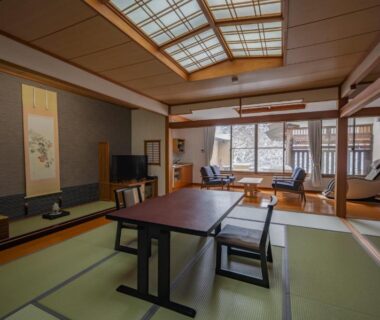 Spacious tatami room with low table, shoji screens and seated area overlooking courtyard at Seifutei, Fukushima