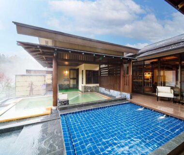Blue tiled outdoor onsen pool with wooden deck at Seifutei ryokan in Fukushima
