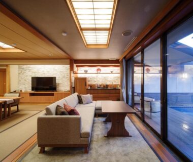 Spacious tatami room with sofa and sliding glass doors to wooden bath at Seifutei Fukushima Tōhoku