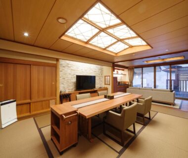 Spacious tatami room with dining table, seating area, shoji screens and balcony at Seifutei in Fukushima
