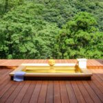 Wooden soaking tub on a deck overlooking lush forest at Seikansou in Kanagawa