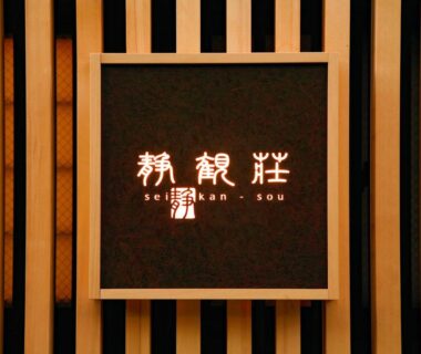 Backlit Seikansou sign with kanji and roman letters mounted on vertical wooden slats