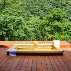 Wooden soaking tub on a deck overlooking lush forest at Seikansou in Kanagawa