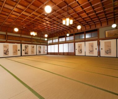 Spacious tatami room with wooden coffered ceiling and painted fusuma at Seikiro Ryokan in Kyoto