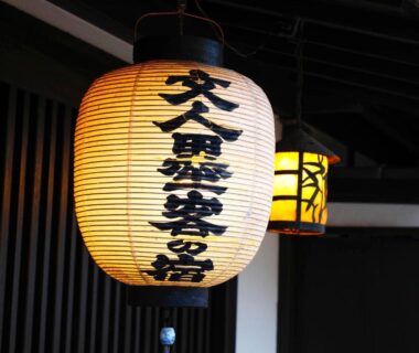 Paper lantern with kanji hanging at Seikiro Ryokan entrance in Kyoto, wooden beams and warm lighting