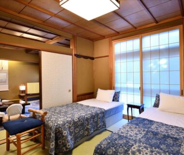 Tatami room with twin beds, shoji screens, low tea table and tokonoma alcove at Seikoro Ryokan Kyoto