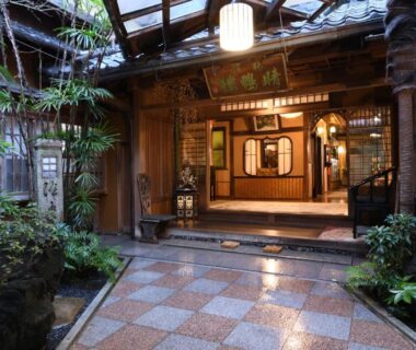 Stone-tiled entrance courtyard with wooden façade, shoji screens and lanterns at Seikoro Ryokan in Kyoto, Kansai