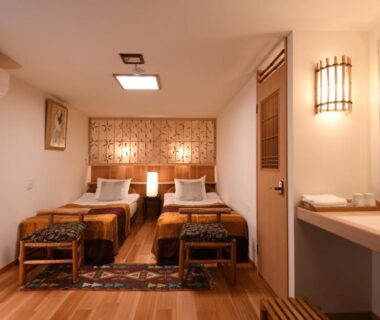 Twin beds with wooden flooring and bedside lamps at Seikoro Ryokan in Kyoto, Kansai