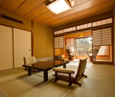 Sunlit tatami room with low table, floor chairs, shoji screens and veranda overlooking a small garden at Seiryu-so