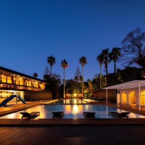 Illuminated outdoor pool with palms and lit ryokan buildings at Seiryu-so in Shizuoka, Chūbu