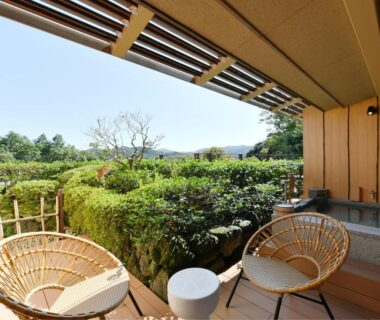 Outdoor terrace with two rattan chairs and wooden bath at Seizan Yamato, Shizuoka