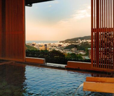 Indoor onsen overlooking coastal town and bay at Seizan Yamato in Shizuoka
