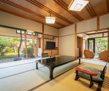 Traditional tatami room with low table, shoji screens and garden visible through sliding doors at Sekitaitei Ishida Nagano