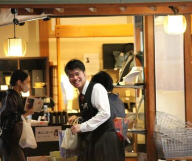 Staff assisting guests at wooden reception with hanging lanterns in Sekitaitei Ishida, Nagano