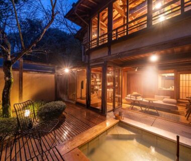 Lit wooden terrace and outdoor bath at Sekitei ryokan in Hiroshima, Chūgoku region