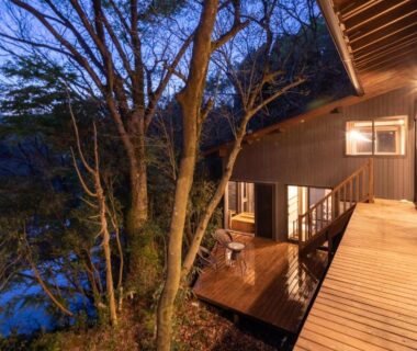 Illuminated wooden veranda with glass doors overlooking trees and water at Sen-no-Mori, Kumamoto, Kyūshū, Japan