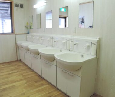 Row of white wash basins with mirrors in a communal sink area at Sendaiya, Gifu, Chūbu, Japan