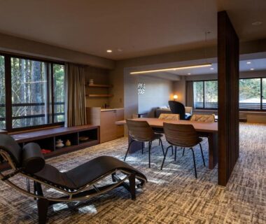 Open-plan ryokan room with chaise lounge, dining table and floor-to-ceiling windows overlooking bamboo grove at Sengokubara COCON, Kanagawa