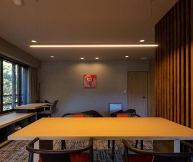 Spacious modern dining area with long wooden table, chairs and large windows overlooking trees at Sengokubara COCON Kanagawa