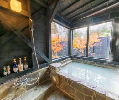 Indoor stone onsen bath with autumn maple view at Sengokuhara Hisanoha, Kanagawa