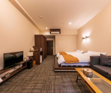 Twin beds and lounge area with sofa and TV at Sengokuhara Hisanoha in Kanagawa