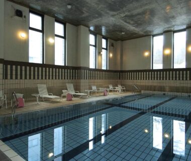 Indoor tiled swimming pool with lane markings and lounge chairs at Senjukaku in Nagano, Chūbu