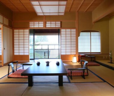 Traditional tatami room with low table, zabuton cushions, shoji screens and tokonoma alcove at Senjukaku, Nagano