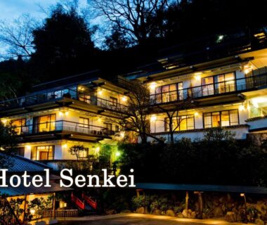 Night exterior of multi-level ryokan with lit balconies at Senkei in Kanagawa, Kantō