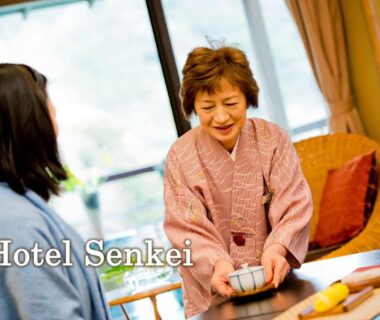 Ryokan attendant in kimono serving tea to guest in tatami room with garden view, Senkei, Kanagawa