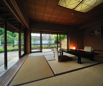 Traditional tatami room with low table, floor seating cushions and garden view at Senkeien Tsukioka Hotel, Yamagata