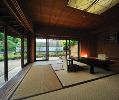 Traditional tatami room with low table, floor seating cushions and garden view at Senkeien Tsukioka Hotel, Yamagata