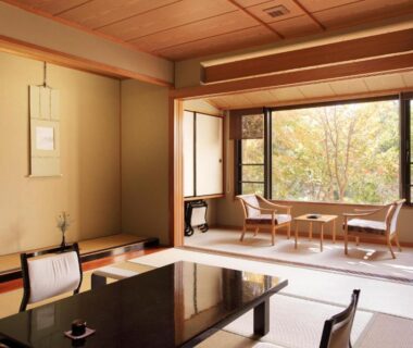 Bright tatami room with low lacquered table, shoji screens and seating by window overlooking trees at Senkyo, Gunma Kantō