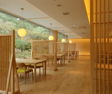 Wooden partitioned dining space with pendant lights at Senkyoro in Kanagawa, Japan