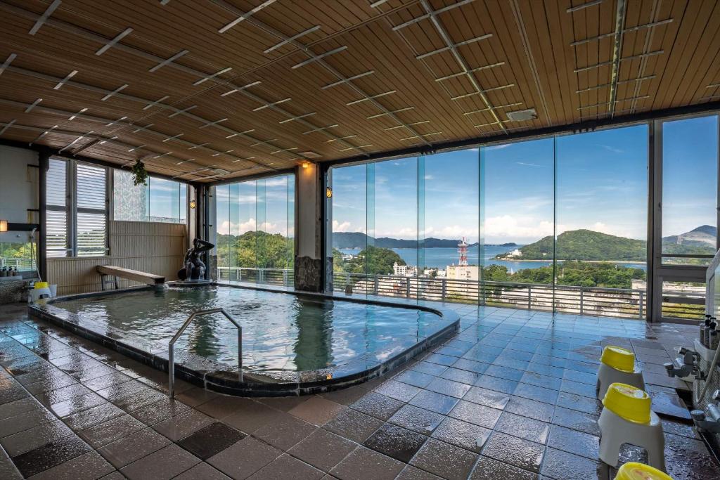 Indoor onsen with scenic view Senpokaku Mie Spacious indoor onsen with large windows showing coastal hills, washing stools visible, Senpokaku, Mie, Kansai, Japan