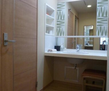 Sink and mirror with wooden door, open shelving and stool at Senshoen, Hokkaidō, Japan