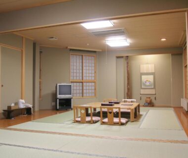 Tatami room with low dining table, shoji screens and alcove at Senshoen in Hokkaidō