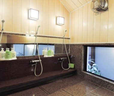 Washing stations with showerheads, stools and toiletries at Senso Yutagawa in Yamagata