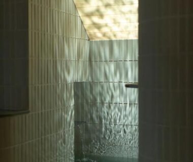 Tiled indoor onsen bath with soft ceiling light at Sensui ryokan in Hyōgo, Kansai