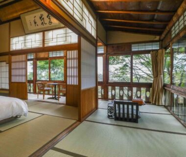Spacious tatami room with futon, shoji screens and wooden veranda at Senzairou in Chūbu, Gifu, Japan