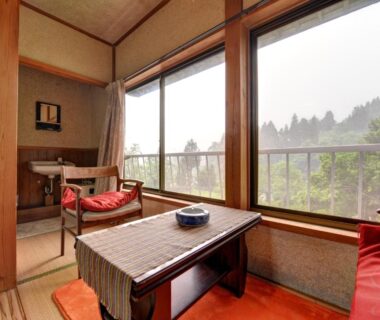 Tatami room with low table, cushions, chair and forest view at Setoguchi, Niigata