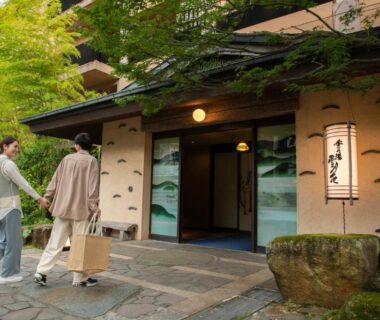 Couple with luggage approaching traditional ryokan entrance at Setsugetsuka in Kanagawa, Kantō, stone path and bamboo greenery