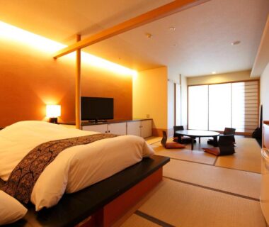 Japanese tatami room with raised western bed, low table, shoji screens and soft ambient lighting