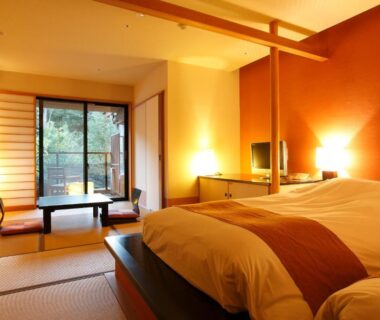 Tatami room with Western bed, low table and shoji screens at Setsugetsuka in Kanagawa