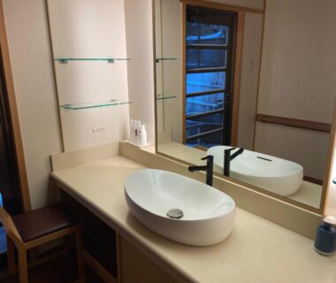 Vessel sink and mirror on ryokan vanity with stool and toiletries in Shaga-no-Sato Yumeya, Niigata