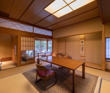 Traditional tatami room with low table, shoji screens, tokonoma and garden view at Shaga-no-Sato Yumeya, Niigata