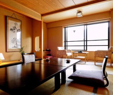 Japanese tatami room with low table, floor cushions, shoji window and wall scroll at Shibu Hotel, Nagano