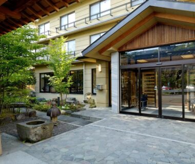 Stone courtyard with wooden eaves and glass entrance at Shibu Hotel, Nagano, Chūbu Japan