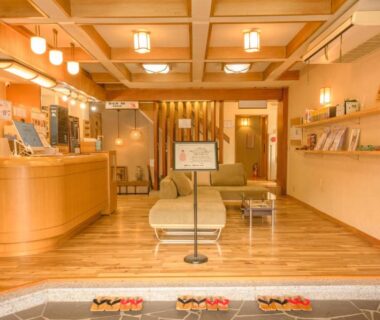Wooden ryokan reception area with seating, slippers at entry and warm lighting, Shibu Onsen KADOYA Nagano