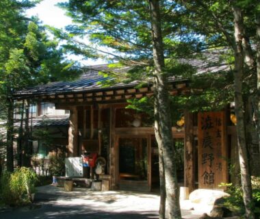 Wooden entrance surrounded by evergreen trees, Shibu Tatunokan, Nagano, Chūbu Japan